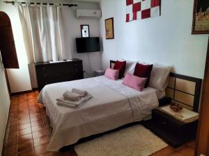 a bedroom with a large bed with pink pillows at Daddos in Flumini di Quartu