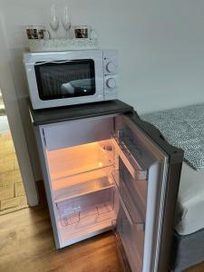 a microwave oven sitting on top of an open refrigerator at Siegen Achenbach 5 in Siegen +5 photos