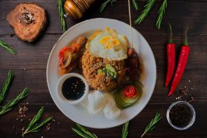 a plate of food with an egg on a table at Nirmala Hotel & Convention Centre in Denpasar