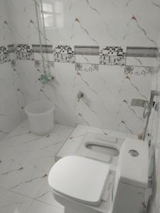 a white bathroom with a toilet and a sink at Pine Peak Lodges in Kālābāgh +57 photos
