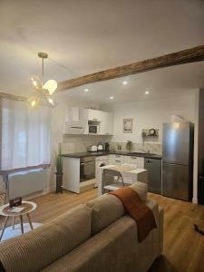 a living room with a couch and a kitchen at "La Tour", Logement cosy, au calme in Vertrieu