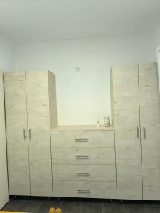 two large wooden cabinets in a white room at Apartmani Mijović in Herceg-Novi