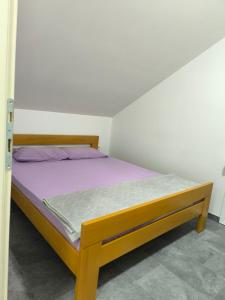 a bedroom with a bed with a purple mattress at Apartmani Mijović in Herceg-Novi