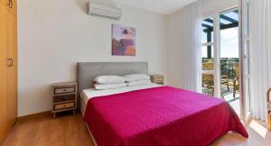 una camera da letto con un grande letto con una coperta rosa di Charming Junior Villa Polemi, in the heart of Aphrodite Hills a Kouklia Altre 35 foto