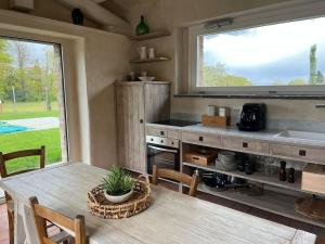 a kitchen with a table and a large window at Agriturismo Il Caio dimora di campagna in Bagnoregio
