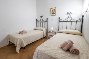 two twin beds in a room with white walls at Cabiedes Marina Golf JC in Rota