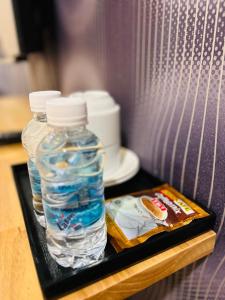 瓜拉丁加奴Ada Hotel & Apartment的托盘上放着两瓶水和一本杂志 更多26张照片