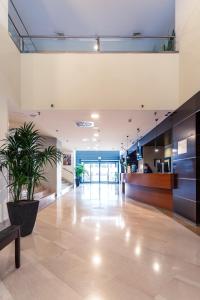 an office lobby with a potted plant in the middle at Mercure Leonardo da Vinci Rome Airport in Fiumicino