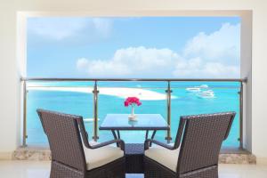 a table with two chairs and a table with a vase of flowers at Triumph White Sands Hotel in Marsa Matruh