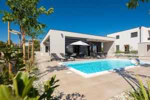 a villa with a swimming pool and a house at Villa M in Vodice