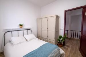 sypialnia z białym łóżkiem i szafką w obiekcie Casa Abuela Toña by Huskalia - city center w mieście Los Llanos de Aridane