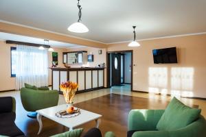 a living room with a table and green chairs at Rai Romanesc in Sălişte