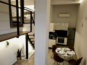 a room with a table and chairs and a kitchen at Cosy Loft in Patra