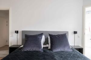 a bedroom with a bed with purple pillows at Lovely City Apartments in Vibrant Area of Copenhagen in Copenhagen +149 photos