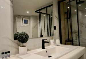 a white bathroom with a sink and a mirror at Cosy Loft in Patra