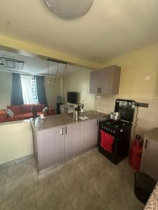 a kitchen and living room with a counter and a stove at Riverside Haven in Ogembo +8 photos