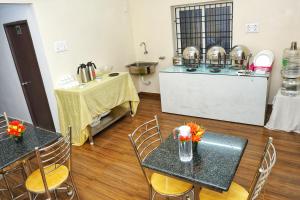 a kitchen with two tables and chairs and a counter at JN Residency Perungudi in Chennai