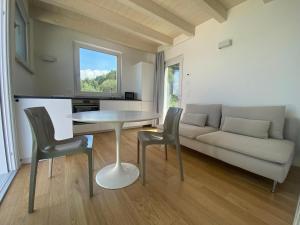 Villa Paola في توري ديل بيناكو: غرفة معيشة مع أريكة وطاولة وكراسي