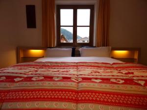 una camera da letto con un letto grande con una finestra di A un passo dal...centro a San Candido