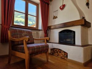 a living room with a chair and a fireplace at Larix Dolomites Lodge in San Candido