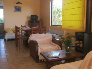 ein Wohnzimmer mit einem Tisch, Stühlen und einem Sofa in der Unterkunft Cabañas Caleta San Pedro in La Serena