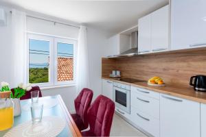 una cucina con tavolo, sedie e finestra di Villa Dundo Marijo a Kručica