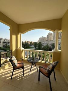a balcony with two chairs and a table on a balcony at Holiday Townhouse 889 in Ras al Khaimah