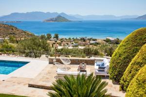 a villa with a pool and a view of the ocean at White Stone Villa in Marathonas