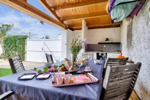 a table with a blue table cloth with food on it at 500m de la plage - Maison 6 adultes & 1 enfant in Barbâtre +9 photos