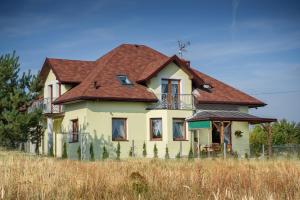 una casa vieja con techo rojo en un campo en Jurajska Stokrotka, en Kotowice