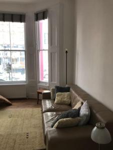 a living room with a couch and two windows at Casa Rosa, Notting Hill in London