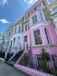 a pink house with a fence in front of it at Casa Rosa, Notting Hill in London