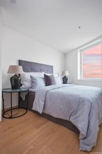 a white bedroom with a large bed and a table at Luxury 3 bedroom seaview apartment, ONS 2024 in Stavanger