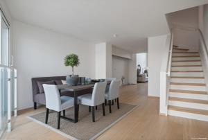 a dining room with a table and chairs and a staircase at Luxury 3 bedroom seaview apartment, ONS 2024 in Stavanger