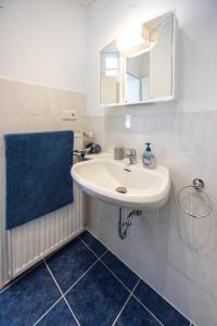 a bathroom with a white sink and a mirror at Bluegate Suite - Airport Guesthouse in Kelsterbach +15 photos