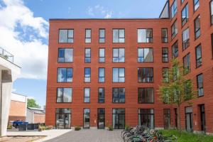 哥本哈根Step-Free Apartment for 8 People Near Amager Beach的一座红砖建筑,前面停放着自行车