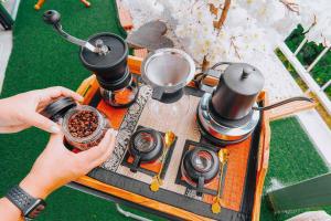 a person is pouring coffee into a pot on a stove at เลสเตอร์ โฮมสเตย์ in Ban Thung Phan Ha