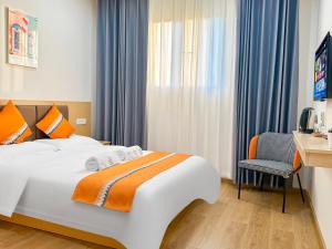 LedineOrange inn Apartment 桔子酒店的一间卧室，配有一张床、一张桌子和一把椅子