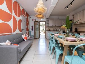 a dining room with a long table and blue chairs at Walk in Hostel Faro Airport in Faro