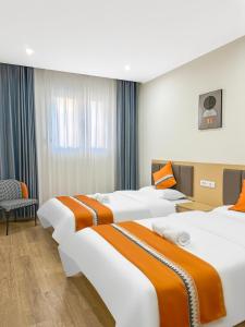LedineOrange inn Apartment 桔子酒店的有两张床和一把椅子的酒店房间