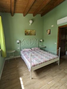 Un dormitorio con una cama en una habitación con paredes verdes. en Villa Torri Appartments, en Torano Nuovo
