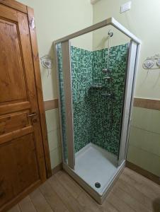 una ducha con puerta de cristal en un baño en Villa Torri Appartments, en Torano Nuovo