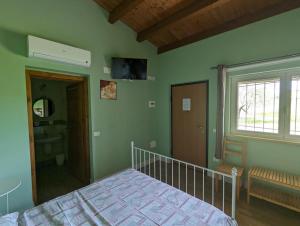 Un dormitorio con paredes verdes y una cama y una ventana. en Villa Torri Appartments, en Torano Nuovo