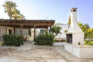 a house with a fireplace in the yard at Tenuta Concamarau in Muro Leccese