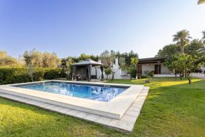 a swimming pool in a yard with a gazebo at Tenuta Concamarau in Muro Leccese