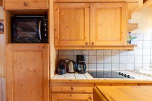 a kitchen with wooden cabinets and a microwave at Saulire 6 in Mussillon
