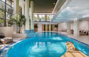 a pool in a hotel lobby with a large swimming pool at Hotel President Solin in Solin