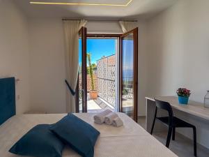 a bedroom with a bed and a table and a balcony at Casa Milly in Agerola