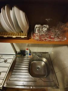 een wastafel in een keuken met borden en borden bij House Hotel Apartments 2 in Rivne