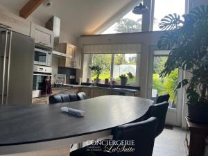 a kitchen with a table with chairs and a large window at La croix Luce in Cherbourg en Cotentin +7 photos
